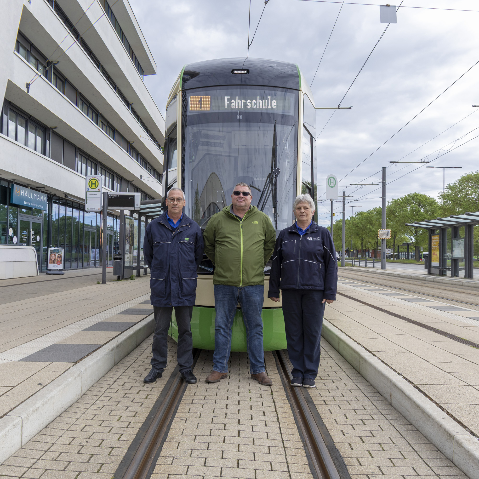 Bildbeschreibung: unsere beiden Fahrlehrer posieren gemeinsam mit dem ersten SKODA Fahrschüler vor der Straßenbahn